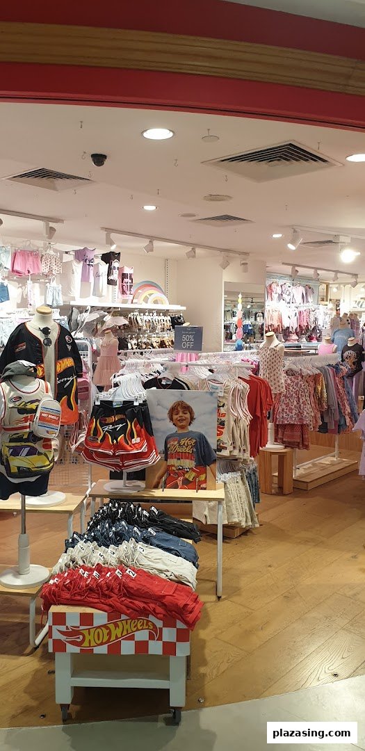 An interior view of Cotton On Kids, showcasing colorful children's apparel and Hot Wheels themed clothing displays.