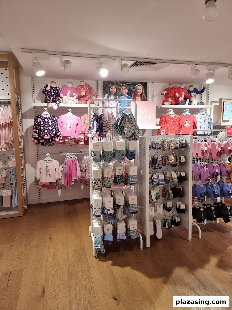 Interior view of Cotton On Kids, showcasing colorful children's clothing, pajamas, socks, and footwear on display.