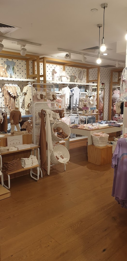 An interior view of Cotton On Kids, showcasing a wide array of baby and children's clothing and accessories.