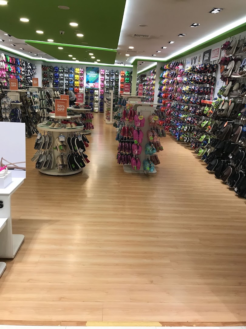 An interior view of a Crocs store showcasing a wide variety of colorful footwear and accessories.
