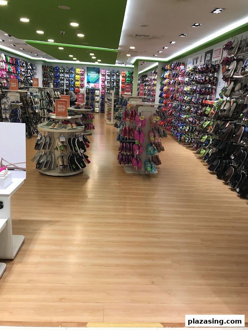 An interior view of a Crocs store showcasing a wide variety of colorful footwear and accessories.
