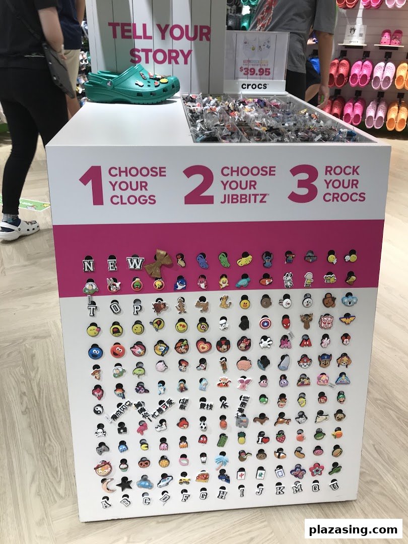 A Crocs in-store display showcasing Jibbitz charms for customizing clogs, inviting customers to personalize their footwear.