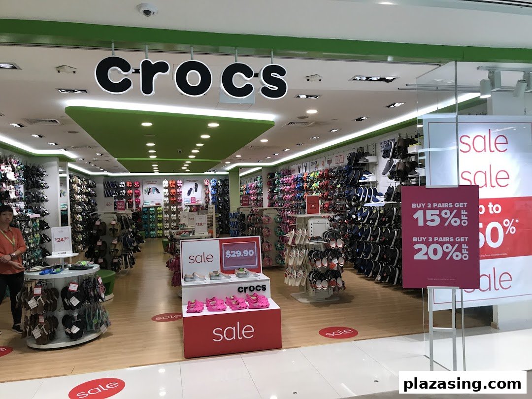 The Crocs store entrance features colorful displays of footwear and prominent sale signs.