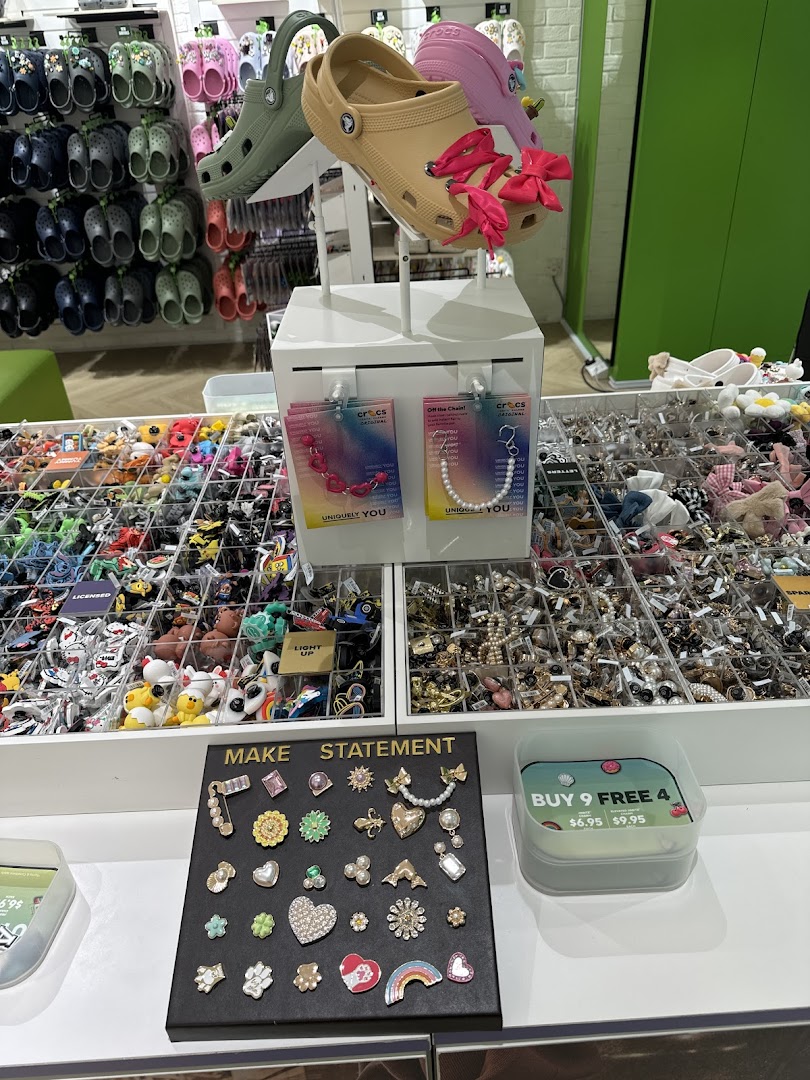 An interior shot of a Crocs store featuring shoes, Jibbitz charms, and various accessories on display.