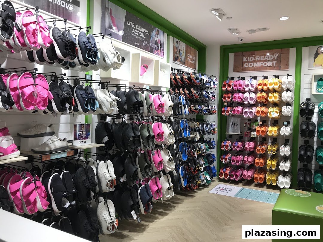 An interior view of a Crocs store showcasing a wide variety of colorful footwear, including clogs, sandals, and sneakers.