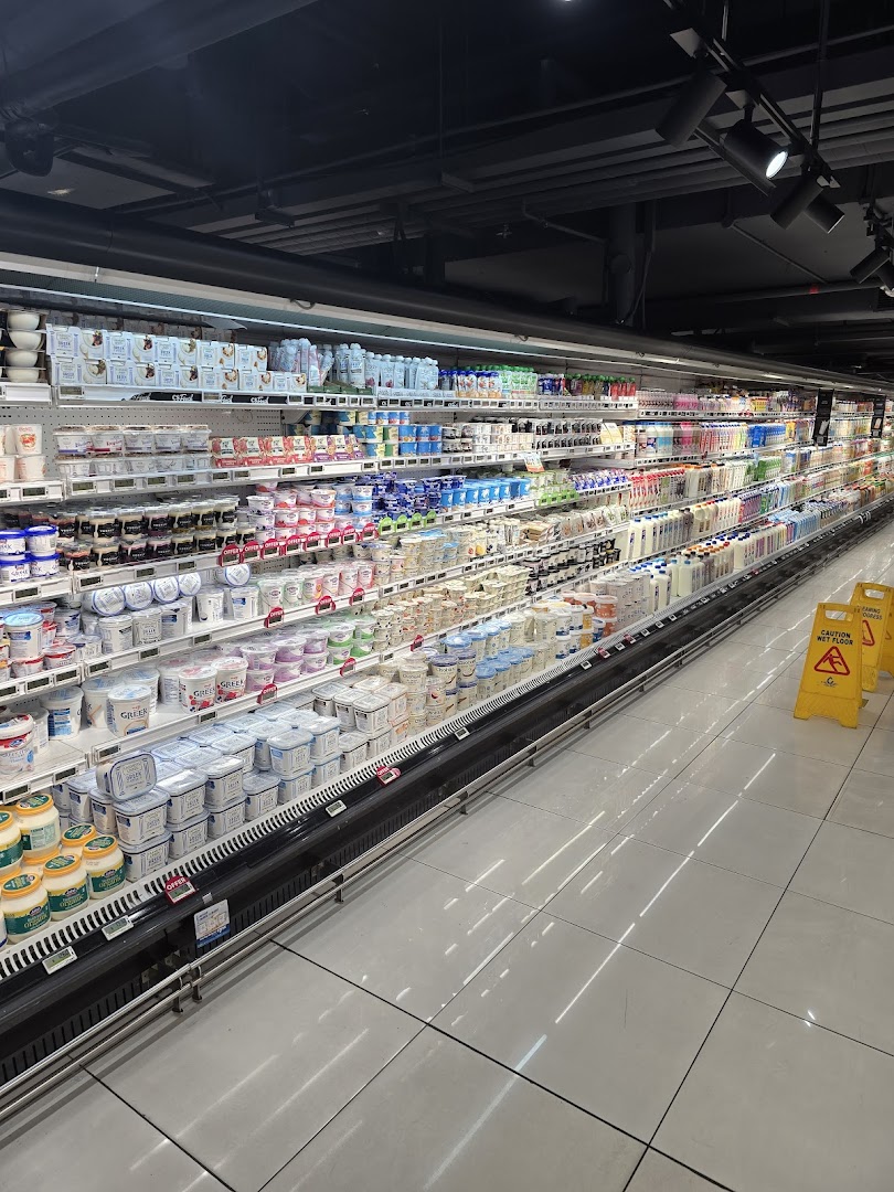 A long refrigerated aisle in CS Fresh, stocked with a wide variety of dairy products.
