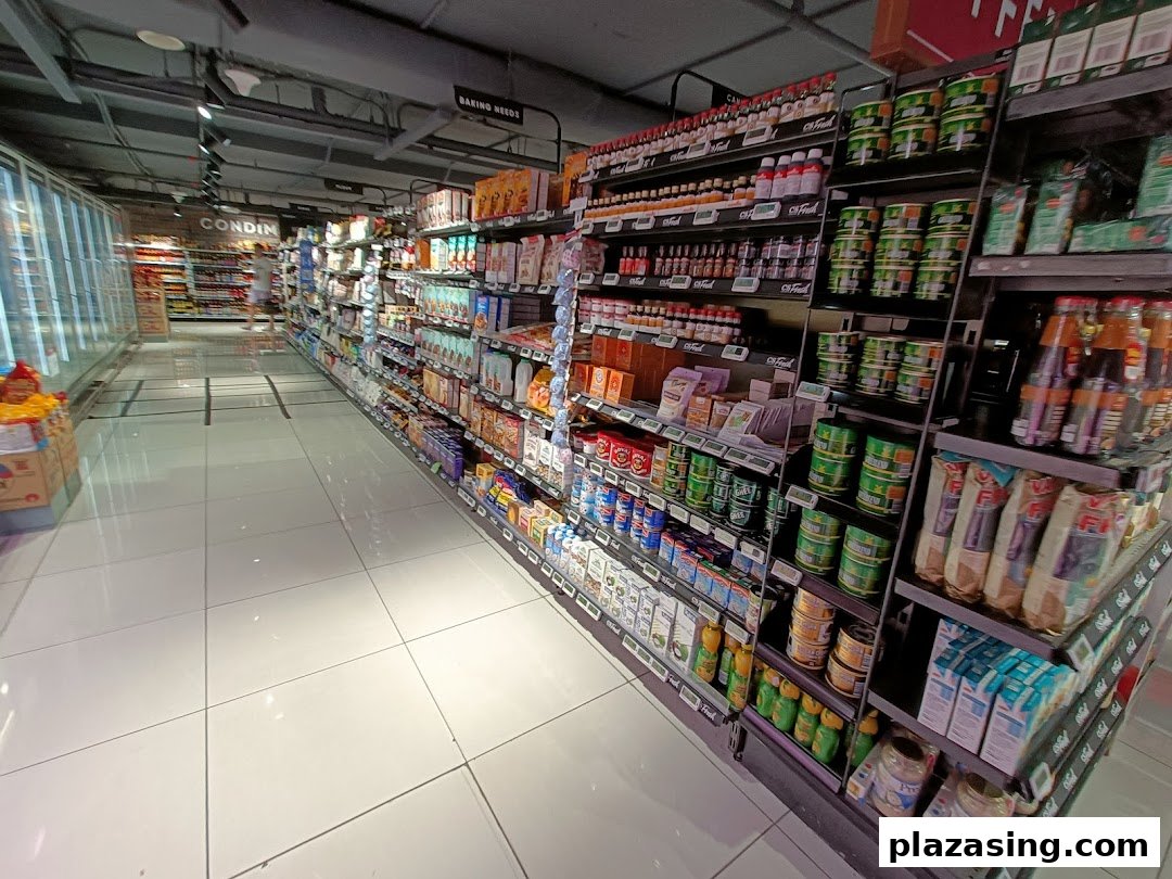 A brightly lit interior view of a CS Fresh supermarket aisle, showcasing a wide array of packaged goods and groceries.