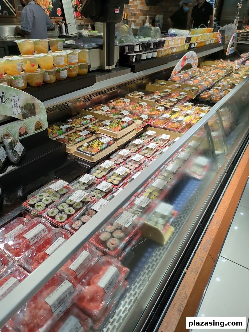 A refrigerated display case filled with various pre-packaged sushi, sashimi, and ready-to-eat meals.