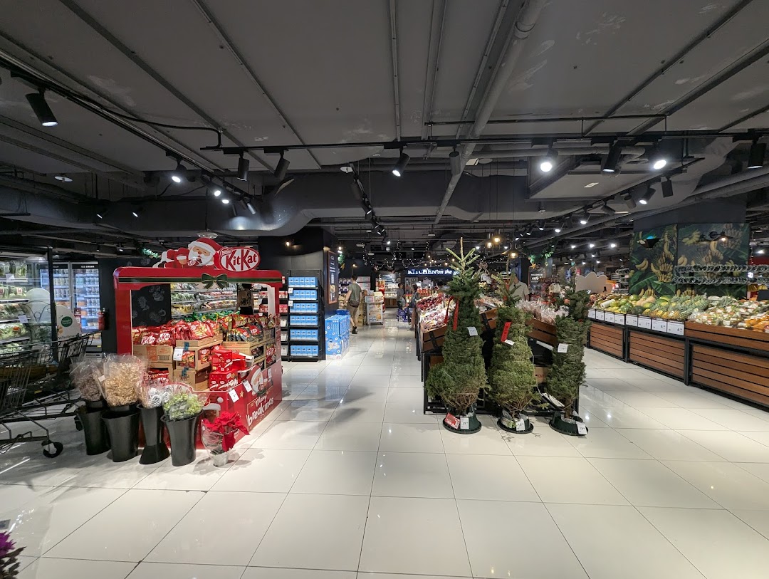An interior view of CS Fresh supermarket, featuring fresh produce, a festive Kit Kat display, and Christmas trees.
