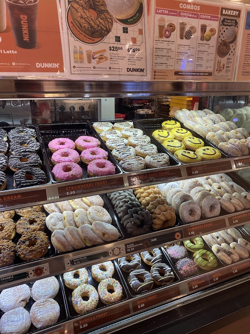 A vibrant display case filled with a variety of colorful donuts and pastries at Dunkin'.