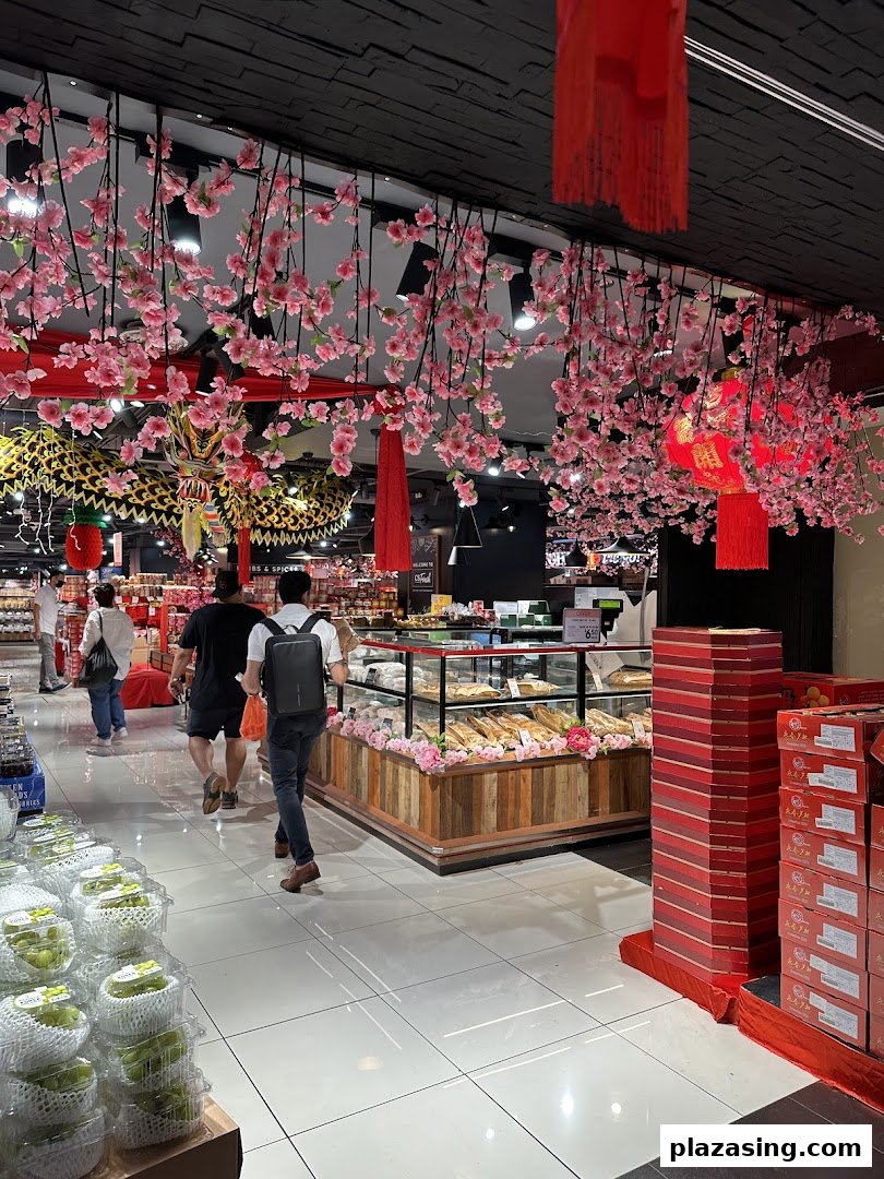 An interior view of CS Fresh, featuring a bakery display, shoppers, and festive cherry blossom decorations.