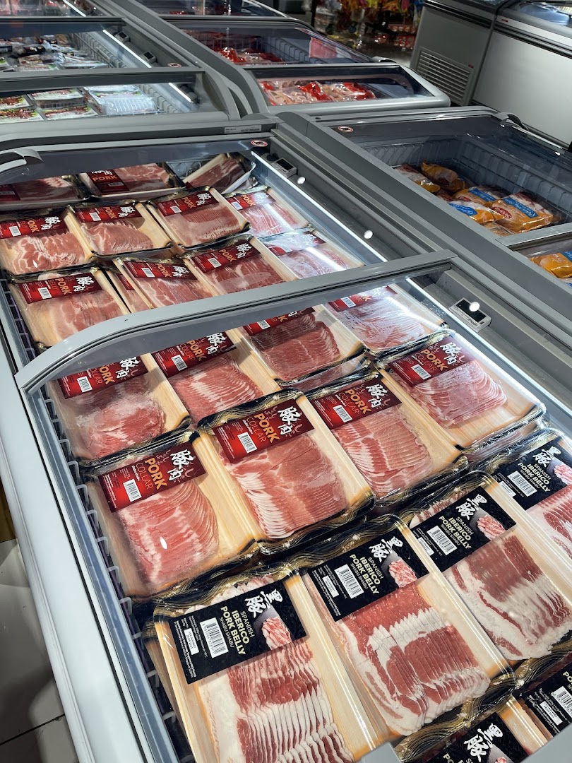 A refrigerated display case at CS Fresh showcasing a variety of packaged pork products, including Iberico pork.