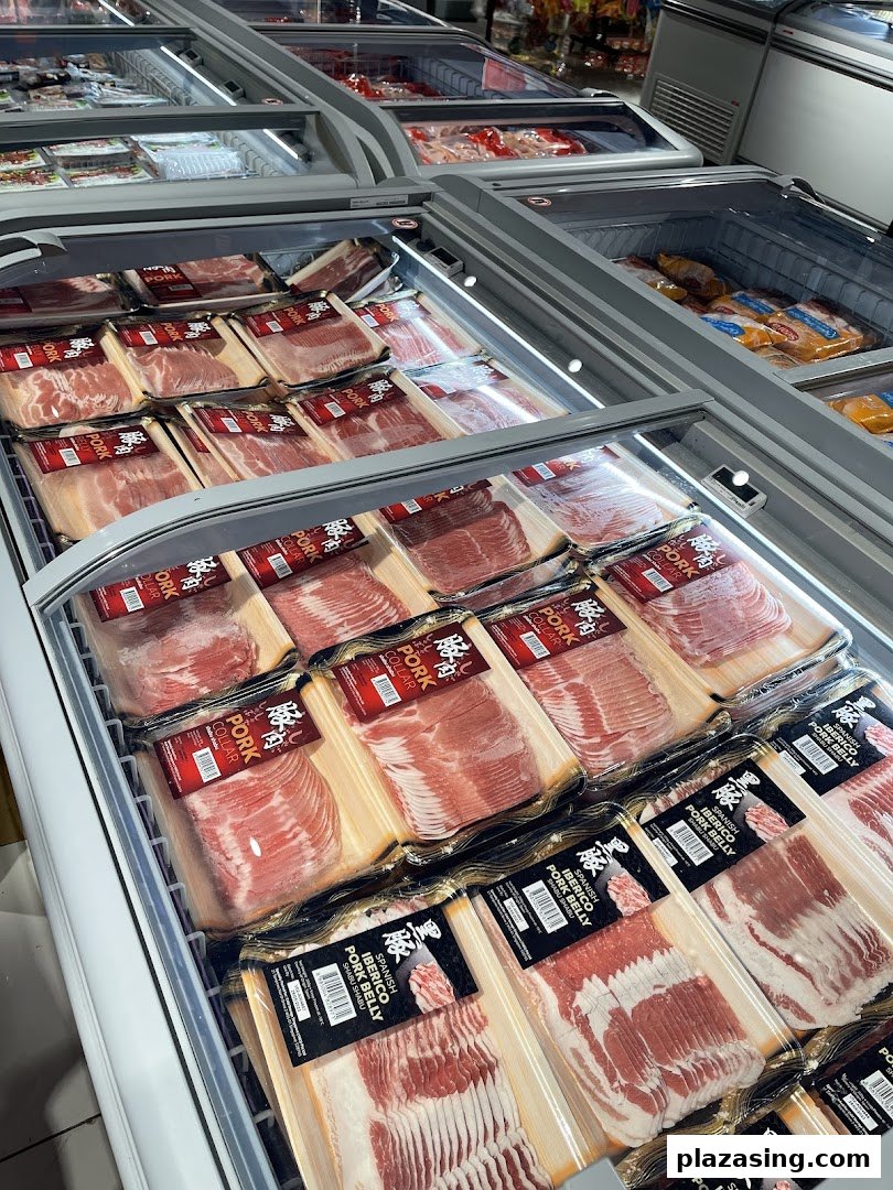 A refrigerated display case at CS Fresh showcasing a variety of packaged pork products, including Iberico pork.