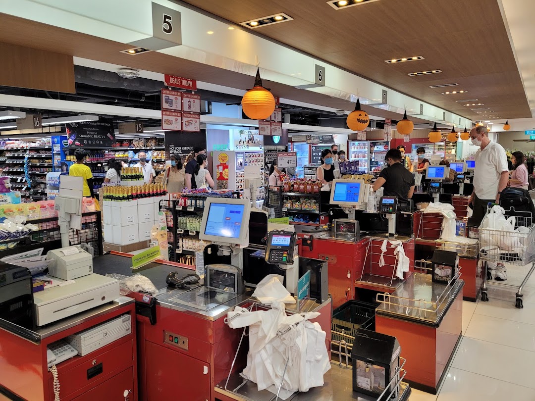 A bustling checkout area at CS Fresh supermarket, with customers and staff, featuring Halloween decorations.