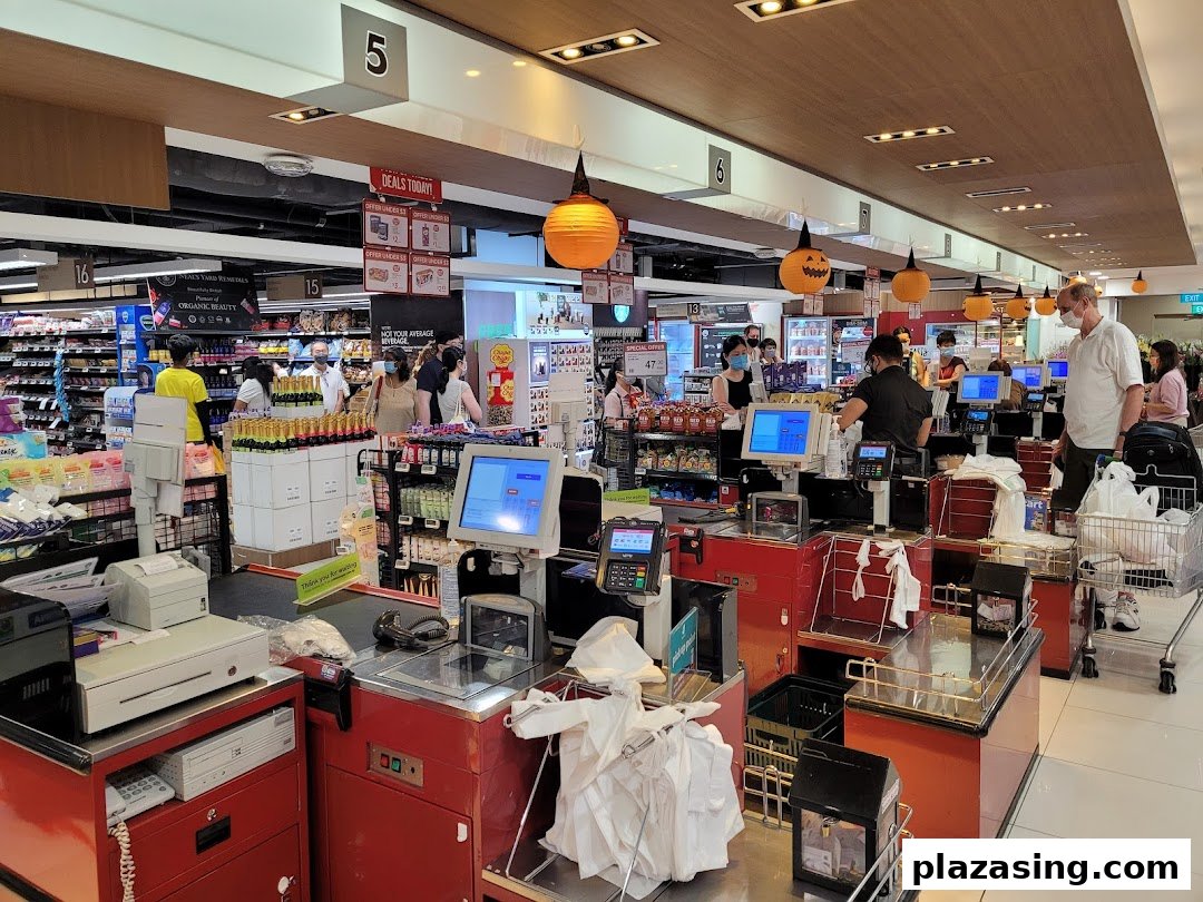 A bustling checkout area at CS Fresh supermarket, with customers and staff, featuring Halloween decorations.