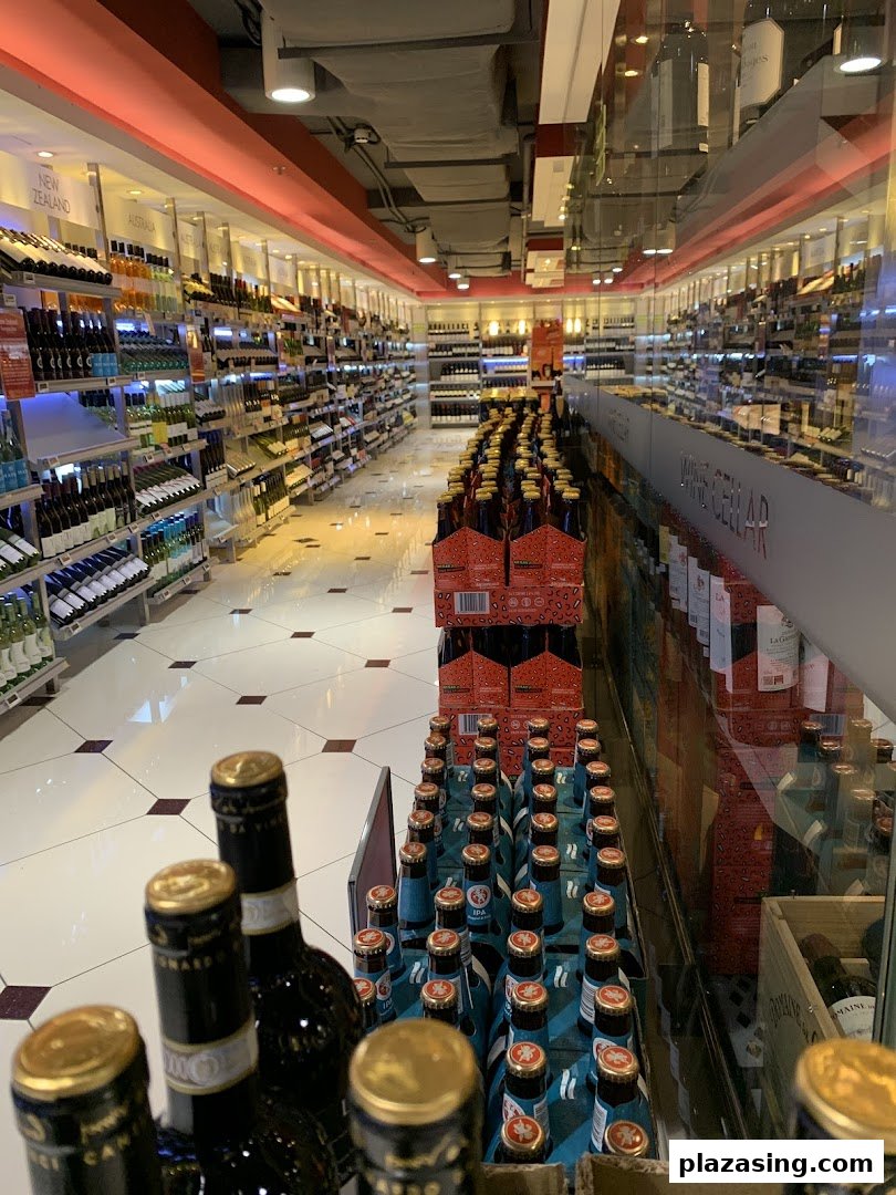 An interior view of a well-stocked aisle in a supermarket, featuring a wide selection of wines and beers.