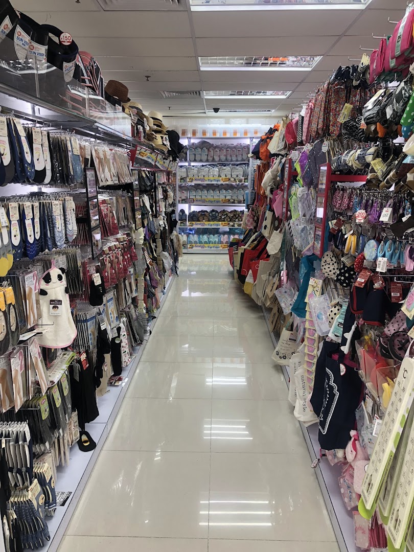An interior view of a DAISO store aisle, showcasing a wide array of everyday goods and accessories.