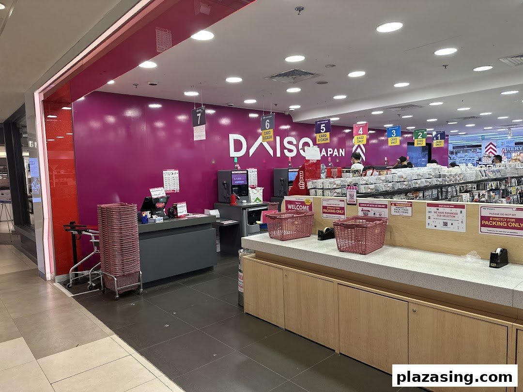 The vibrant pink entrance and checkout area of Daiso Japan, featuring multiple self-checkout counters.