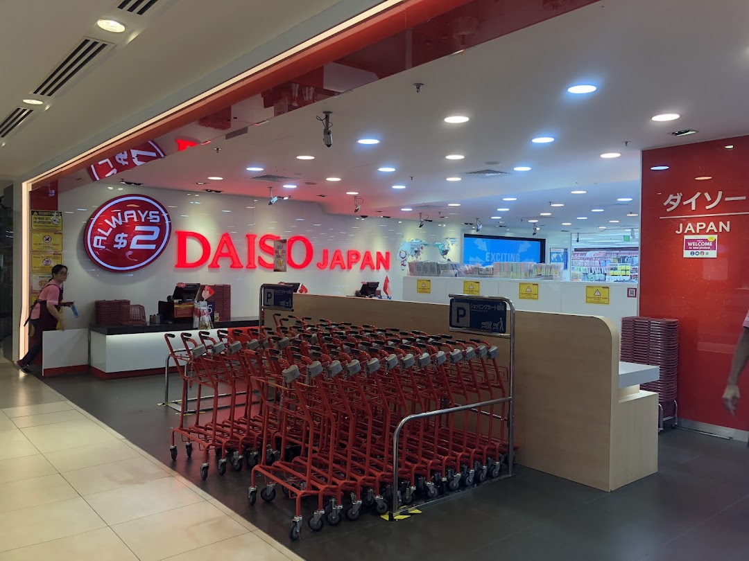 The brightly lit entrance of Daiso Japan, featuring its red logo, 'Always $2' sign, and a row of shopping carts.