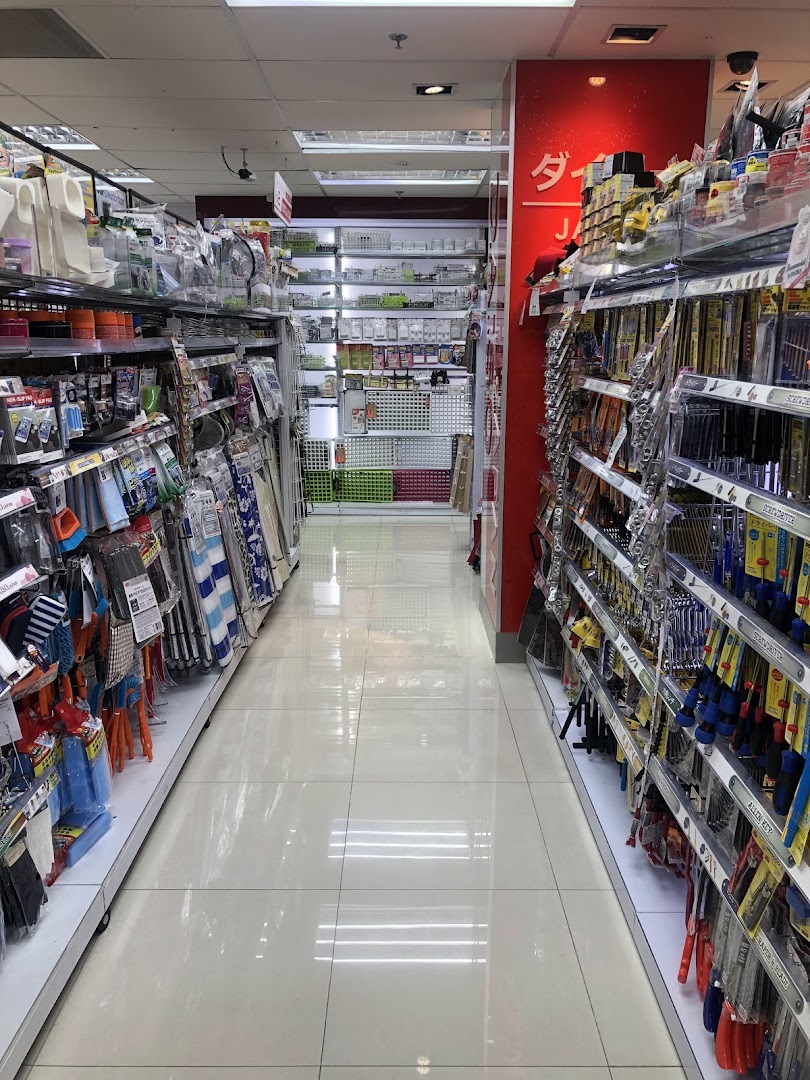 An interior view of a DAISO store aisle, showcasing shelves filled with diverse household and lifestyle products.