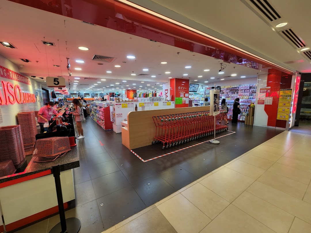The bright red and white entrance of Daiso Japan, showcasing shopping carts, checkout, and product aisles.
