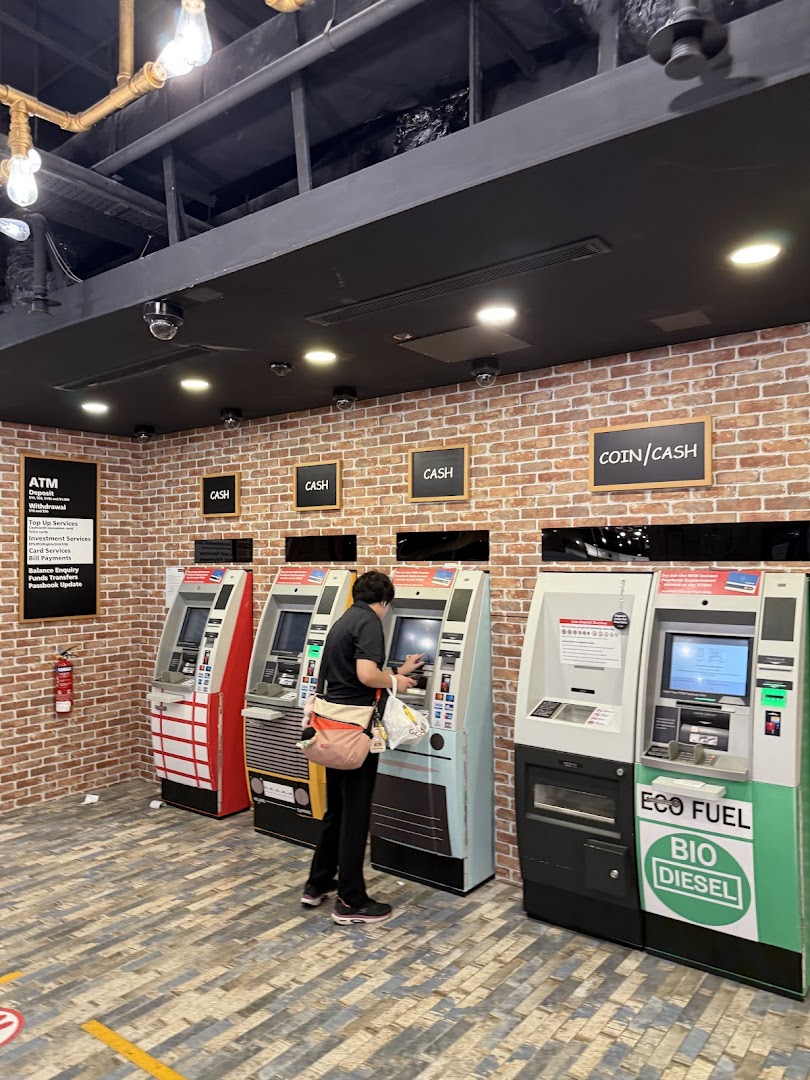 A customer uses one of several DBS ATMs in a brick-walled banking area at Plaza Singapura.
