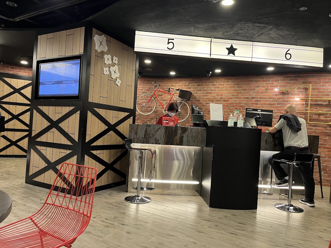 Interior view of a modern bank branch with service counters, a waiting area, and a customer being served.