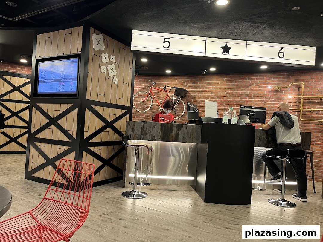 Interior view of a modern bank branch with service counters, a waiting area, and a customer being served.
