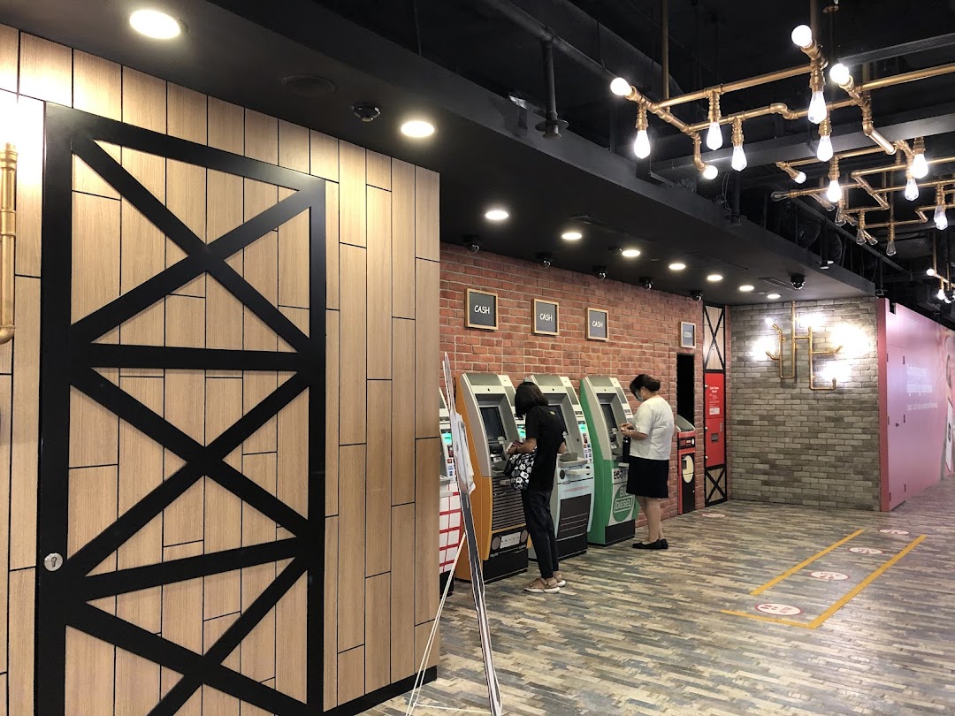 Customers utilize ATMs within the modern interior of a DBS bank branch at Plaza Singapura.