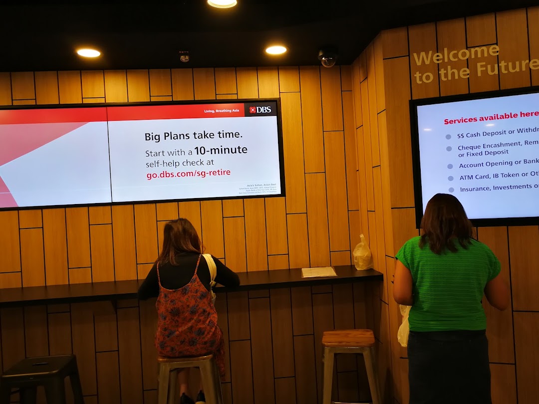 Customers utilize digital self-service screens within the modern DBS Plaza Singapura bank branch.