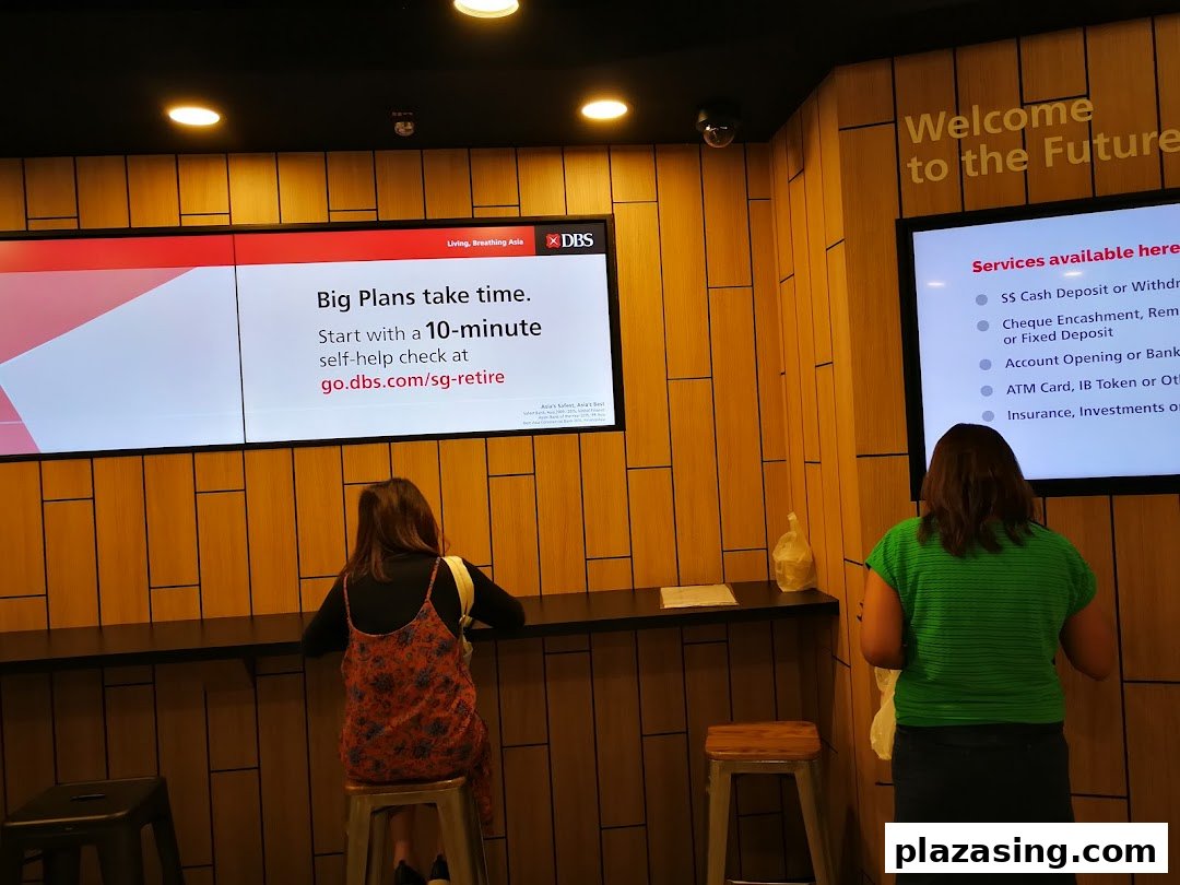 Customers utilize digital self-service screens within the modern DBS Plaza Singapura bank branch.