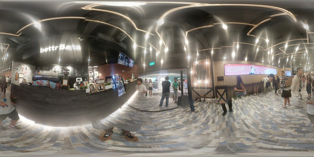 An interior view of Bettr Barista cafe, featuring a coffee counter, seating areas, and customers.