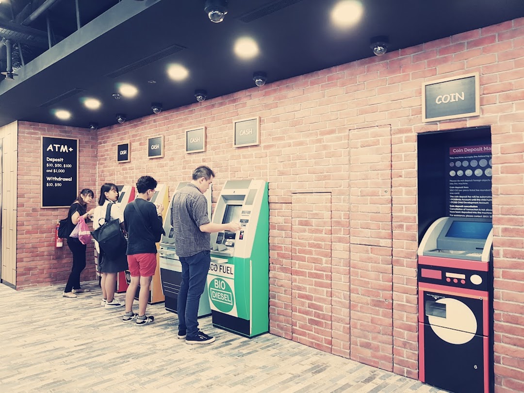 Customers use ATMs and a coin deposit machine at a modern DBS bank branch.