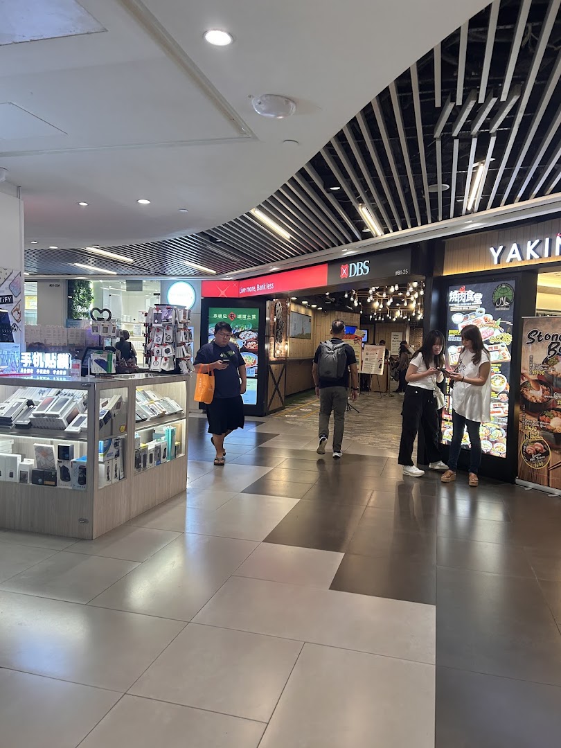 The entrance of DBS Plaza Singapura Branch is visible, with shoppers passing by and a nearby restaurant.