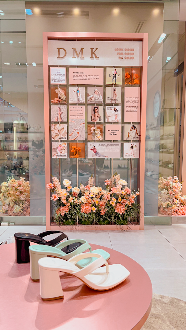 A stylish interior display at DMK, showcasing fashionable shoes and a decorative brand story wall.