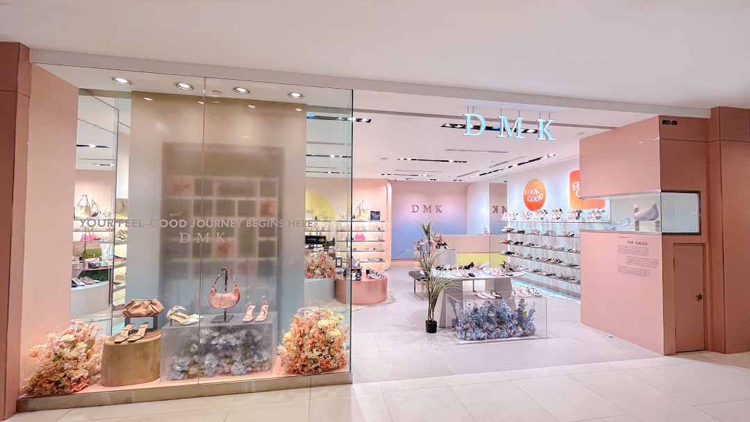 The storefront of DMK, a stylish shoe and bag shop, featuring pastel interiors and elegant product displays.
