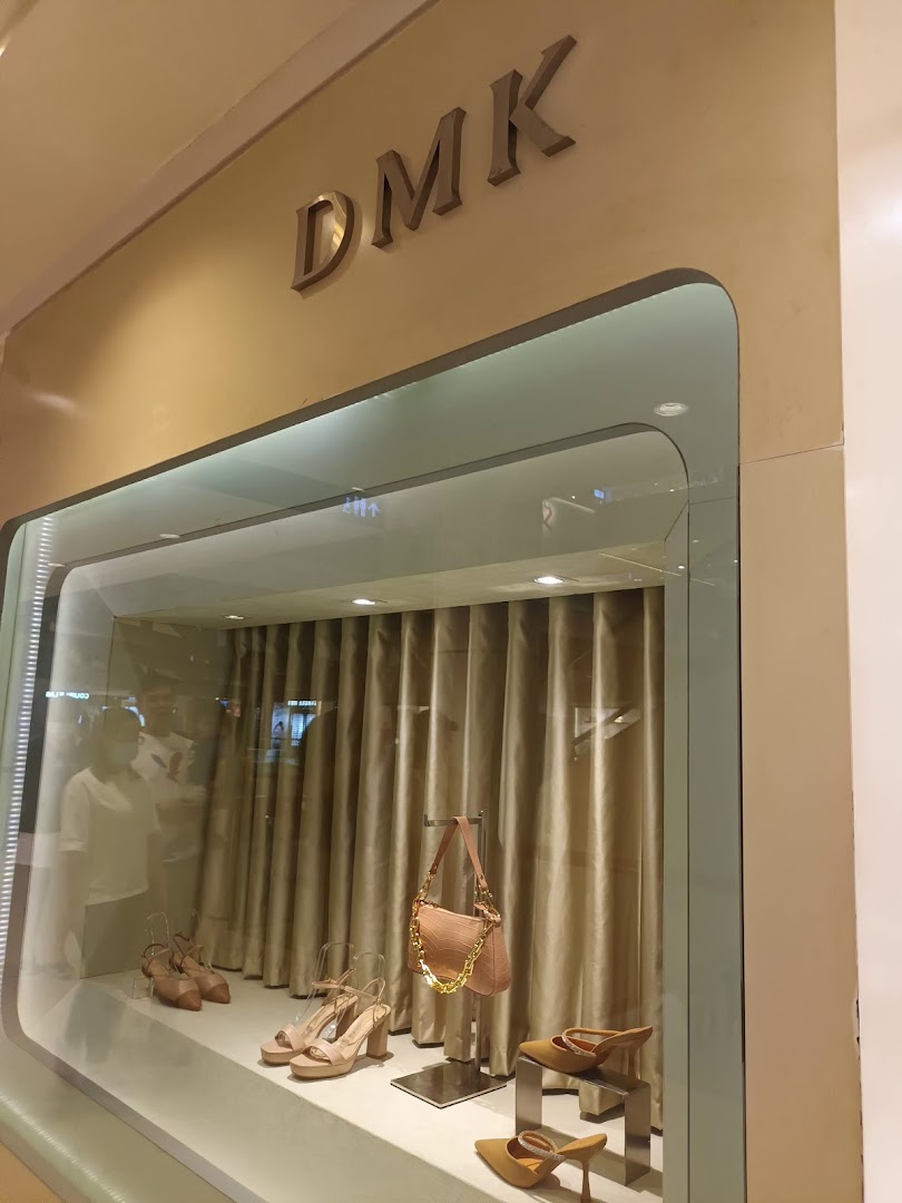 The DMK shopfront display window showcases stylish shoes and a matching handbag.