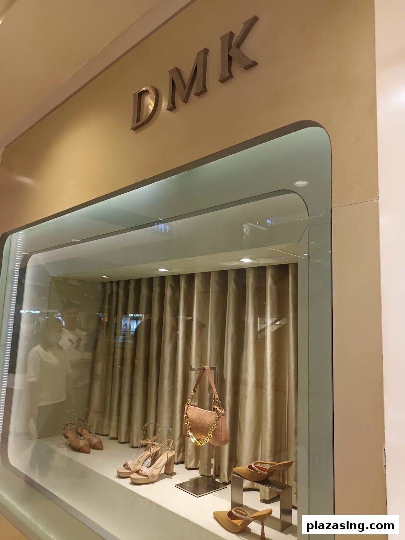 The DMK shopfront display window showcases stylish shoes and a matching handbag.