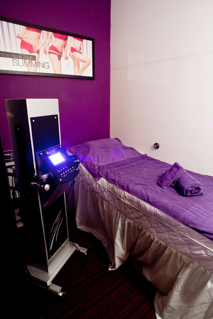 An interior view of a Dorra Slimming treatment room with a bed and a slimming machine.