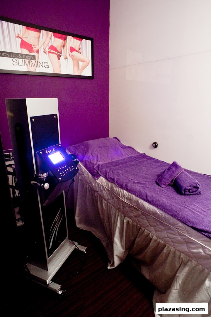 An interior view of a Dorra Slimming treatment room with a bed and a slimming machine.