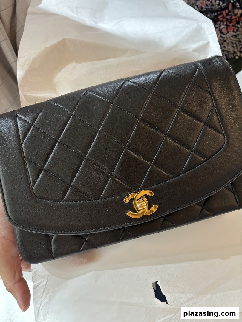 Close-up of a luxurious black quilted handbag with a prominent gold CC logo.