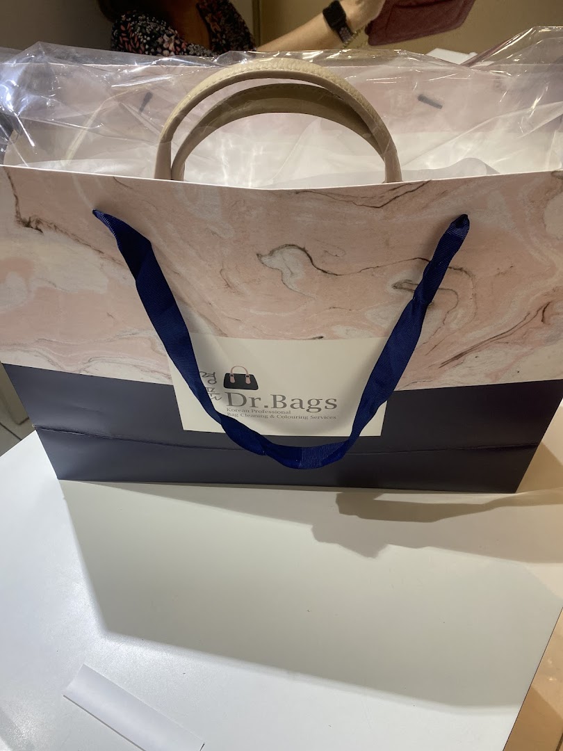 A Dr. Bags shopping bag with a newly serviced item inside, showcasing their branding.
