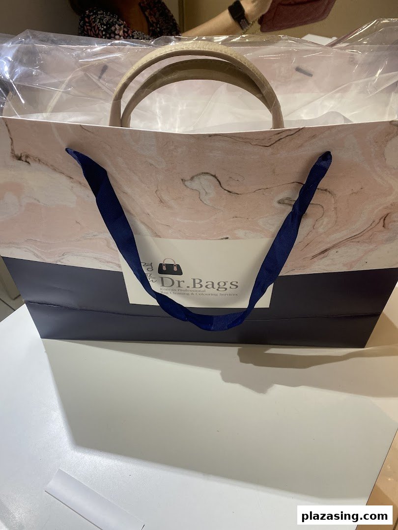 A Dr. Bags shopping bag with a newly serviced item inside, showcasing their branding.