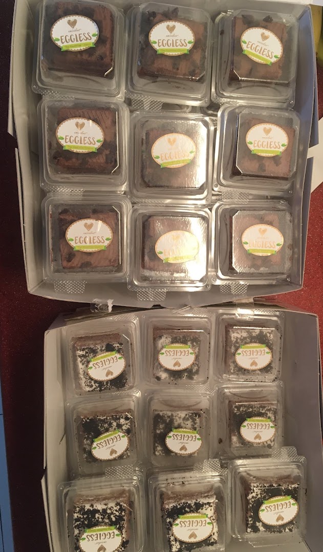 Two boxes filled with individually packaged eggless brownies or cakes, ready for enjoyment.