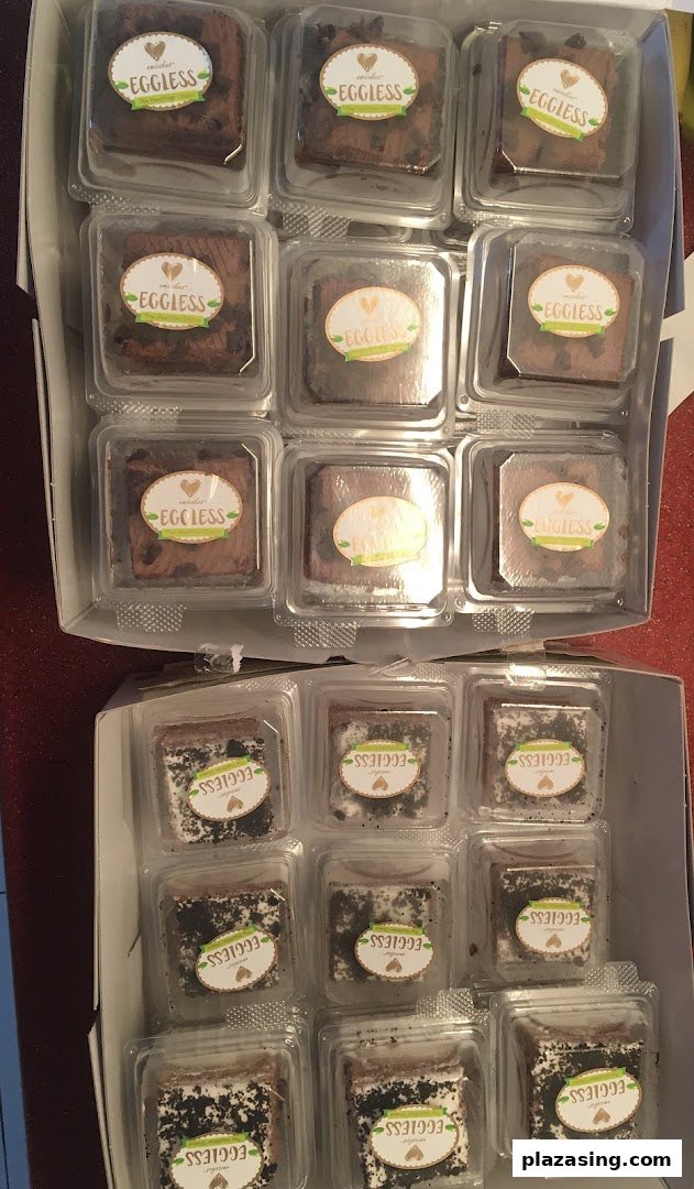 Two boxes filled with individually packaged eggless brownies or cakes, ready for enjoyment.