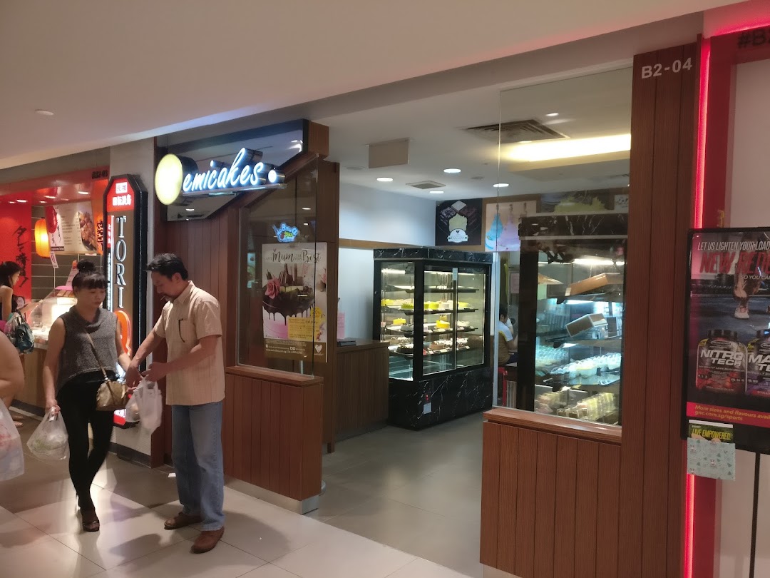 The Emicakes shop entrance at Plaza Singapura, showcasing its cake and pastry displays.