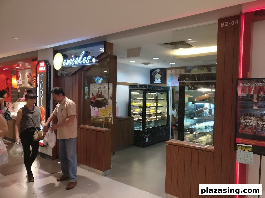 The Emicakes shop entrance at Plaza Singapura, showcasing its cake and pastry displays.