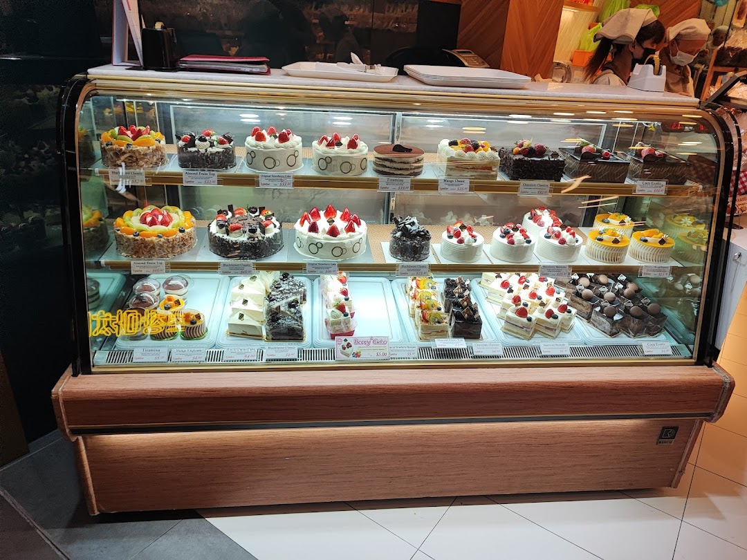 A refrigerated display case showcasing a variety of beautifully decorated cakes and pastries.