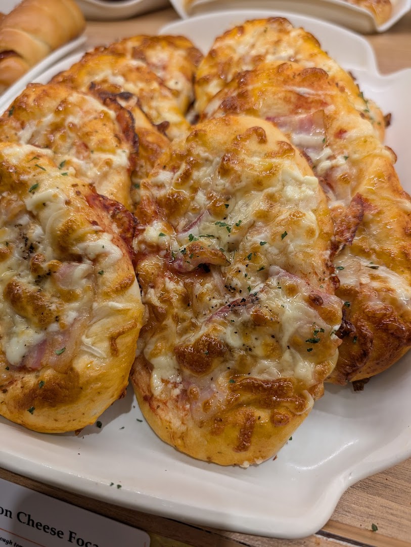 Delicious golden-baked cheese and ham focaccia buns displayed on a white platter at Epi Dor.