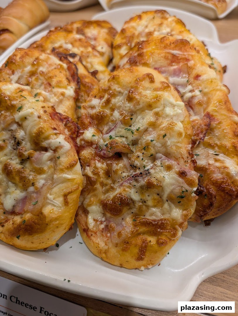 Delicious golden-baked cheese and ham focaccia buns displayed on a white platter at Epi Dor.